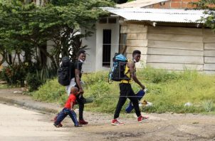 Migrantes caminan por la localidad colombiana de Necoclí, en la frontera con Panamá. Foto: EFE