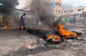 Un policía intenta disipar una barricada en llamas durante una jornada de protesta en Pétion-ville (Haití). EFE