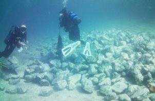 Imagen cedida por el Ministerio griego de Cultura de los arqueólogos examinando rocas en la parte sumergida del asentamiento prehistórico encontrado en Grecia.
