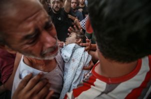 El abuelo del niño Alaa Qadoum, de cinco años, llora mientras carga su cuerpo durante su funeral. Foto:EFE