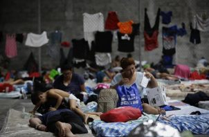 Personas migrantes de origen venezolano, incluidos niños, descansan en un refugio temporal.
