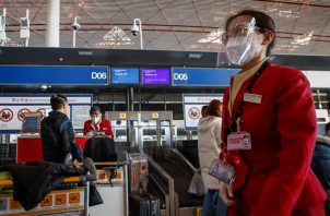 Personal de las líneas aéreas atiende a los pasajeros en el Aeropuerto Internacional de Pekín el 30 de noviembre de 2022. EFE