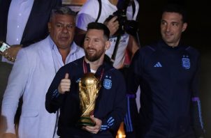 Messi con el trofeo de campeón del mundo, el técnico Scaloni (der.)  y Claudio 'Chiqui' Tapia de la AFA. Foto:EFE