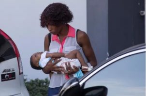 Una mujer, con su bebé en brazos, camina en el Hospital Materno Infantil San Lorenzo de los Mina, en Santo Domingo. Foto: EFE 