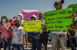 Migrantes protestan por la falta de vacunas y atención médica ante el brote de varicela al exterior del Consulado de Estados Unidos. Foto: EFE
