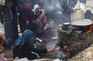 Palestinos desplazados internos preparan pan con leña ante la escasez de gas en los campos de refugiados de la ciudad de Rafah. Foto: EFE
