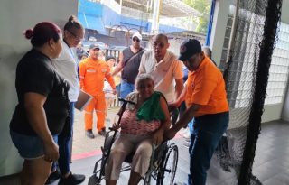 Personal del Sinaproc brinda asistencia a una mujer con movilidad reducida. Cortesía