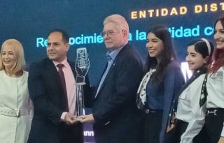 Carlos Sánchez Fábrega, gerente de MiBus, recibe el reconocimiento de parte de Javier Garrido, director de Ciencias de la Información de la AIG, como la empresa  con mejor calidad de atención ciudadana en el año en curso. Pancho Paz