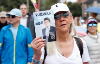 Una mujer sostiene un cartel durante una caminata por la paz y en apoyo al senador Miguel Uribe Turbay. Foto: EFE