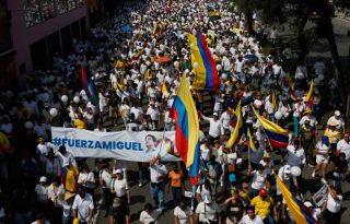  Personas se manifiestan con carteles y banderas durante la 