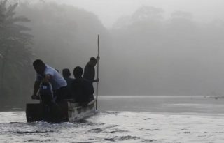 Fotografía de personas a bordo de una canoa en Bajo Chiquito (Panamá). Foto: EFE/ Moncho Torres