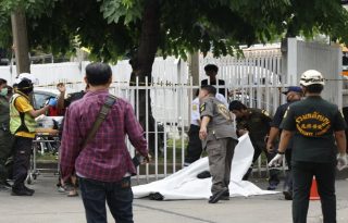 Miembros de los equipos de emergencia cubren a una víctima mortal del tiroteo registrado en un mercado de Bangkok. Foto:EFE