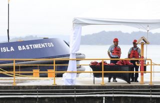 Funcionarios esperan junto al remolcador 'Isla Bastimentos' durante una ceremonia institucional, ayer, viernes, en un muelle del Canal de Panamá. EFE/ Bienvenido Velasco