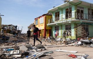 Personas caminan por una calle destruida por el paso del huracán Melissa, en Black River (Jamaica). Foto: EFE