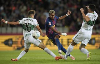  El delantero del Barcelona Lamine Yamal (c) dispara a puerta para marcar el primer gol del equipo ante el Elche,. Foto: EFE