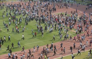 Los aficionados lanzan botellas y sillas, vandalizando vallas publicitarias en el Salt Lake Stadium. Foto: EFE