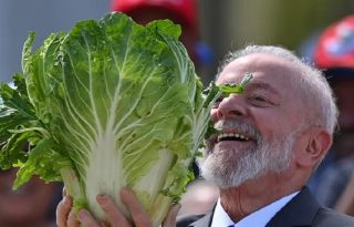 El presidente de Brasil, Luiz Inácio Lula da Silva, sostiene una bietola mientras visita una feria de verduras en una foto de archivo. EFE/ André Borges