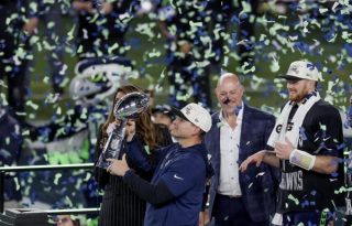 El entrenador en jefe de los Seahawks, Mike MacDonald (2-L), sostiene el Trofeo Vince Lombardi después de que los Seahawks derrotaran a los Patriots de Nueva Inglaterra en el Super Bowl LX.  Foto: EFE