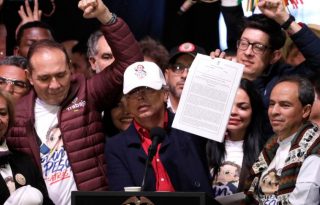 El presidente de Colombia, Gustavo Petro, sostiene el nuevo decreto del salario. Foto: EFE
