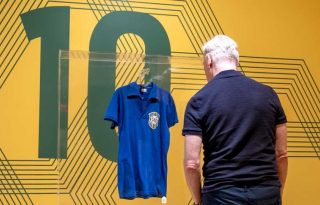 Una persona observa la camiseta que Pelé vistió en la final del Mundial de Suecia 1958. Foto EFE