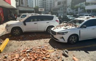 Vehículos afectados por restos de un edificio tras terremoto. Foto: EFE 
