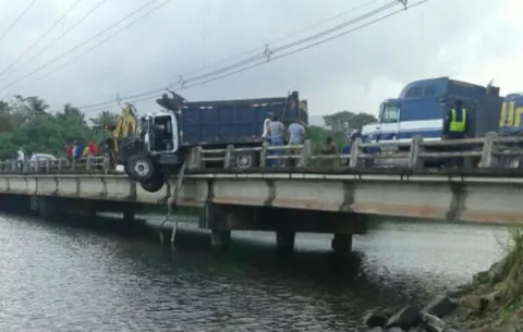 Camión choca con el puente de Río Piedra y queda colgando