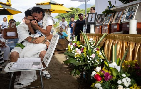  su hermana, Paola Suárez sostienen imágenes de sus familiares fallecidos. Foto: EFE