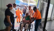 Personal del Sinaproc brinda asistencia a una mujer con movilidad reducida. Cortesía