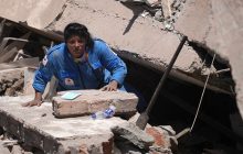 Una integrante de la Cruz Roja de Colombia busca entre los escombros de una edificación colapsada. Foto: EFE