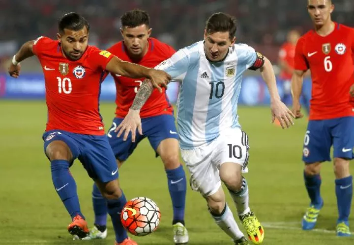 Lionel Messi  trata de escapar de los chilenos.  / EFE