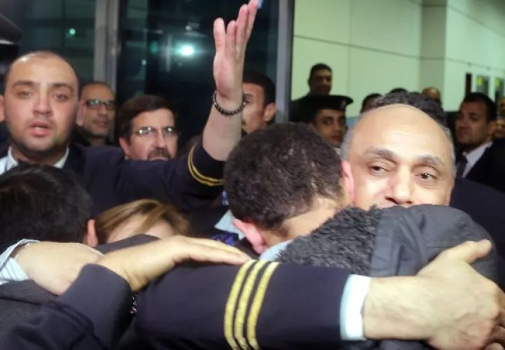 El piloto Amr al-Jamal  se abraza con uno de los pasajeros.  / EFE