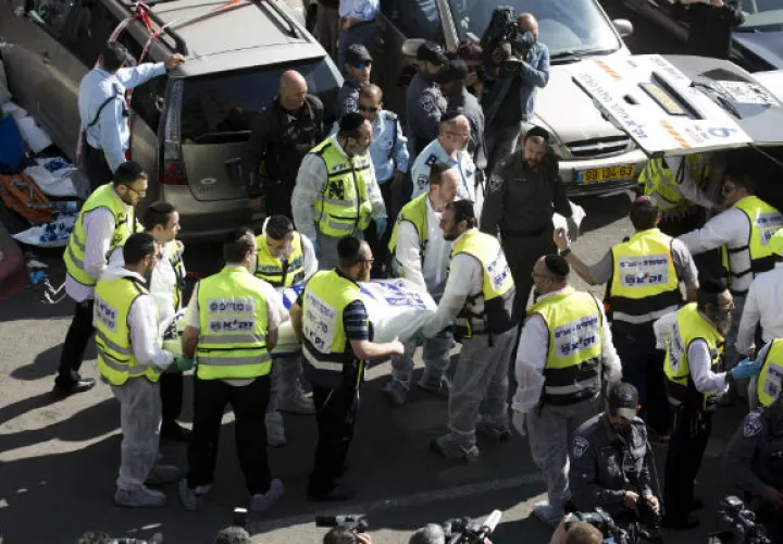 Personal del servicio de emergencias retira el cuerpo de una víctima. Foto EFE