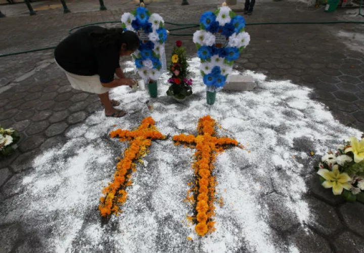Cruces de flores en honor a las víctimas. Foto/ AP