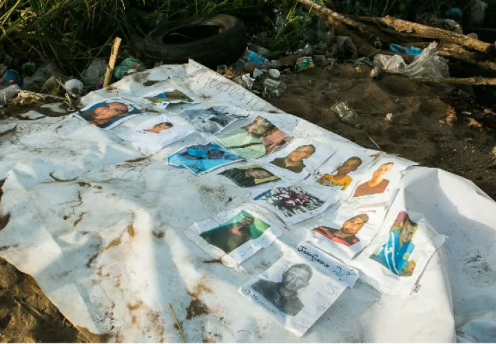 Fotografía de un cartel con imágenes de los mineros desaparecidos. Foto: EFE 