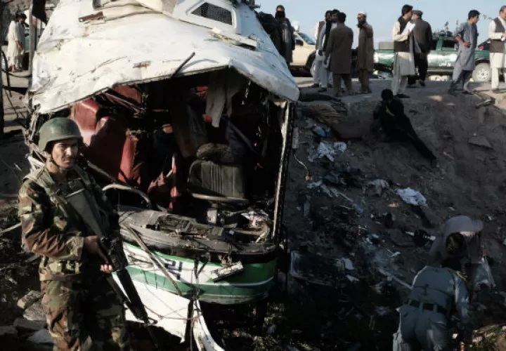 Afganos inspeccionan los daños de un autobús. Foto: AP 