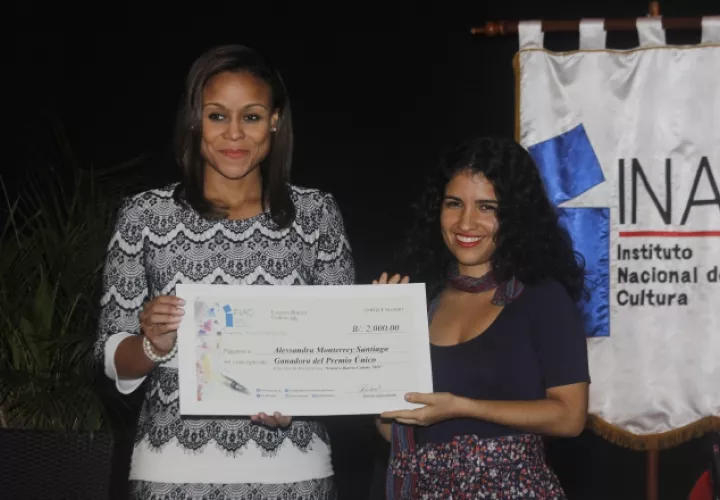 Janelle Davidson, directora general del Instituto Nacional de Cultura entrega a Alessandra Monterrey Santiago el cheque por $2,000. /Foto Jenny Acosta.