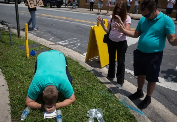 Varias personas oran por las víctimas de la masacre que ocurrió la madrugada de ayer en Orlando. /Foto AP