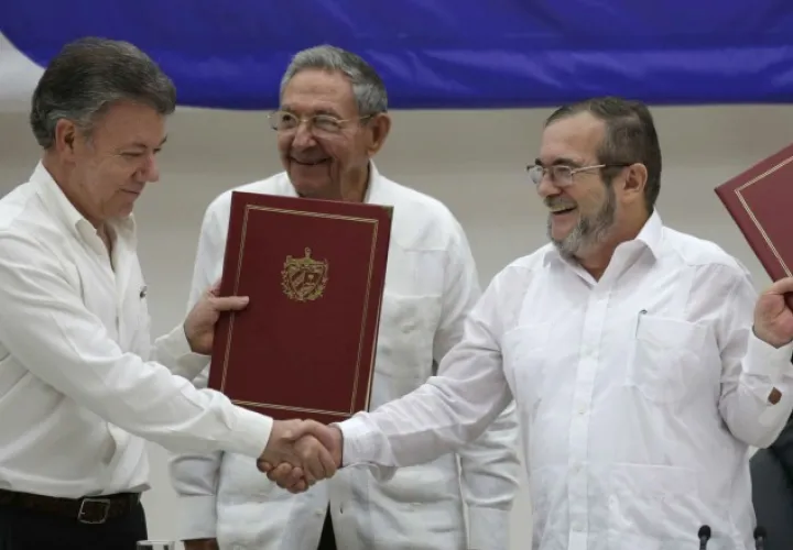 El presidente Juan Manuel Santos y Rodrigo Londoño, alias "Timochenko", en un momento histórico para Colombia. /Foto AP