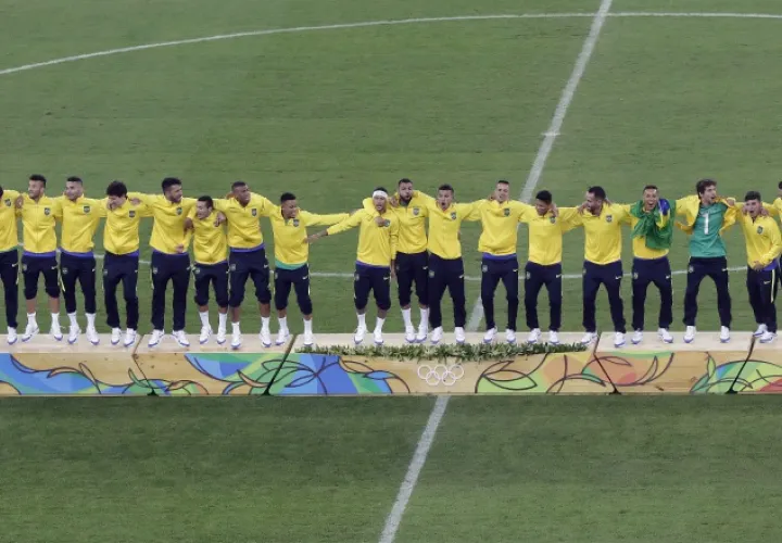 Jugadores brasileños celebran en el podio la victoria y medalla de oro conseguida en los Juegos Olímpicos 2016. AP