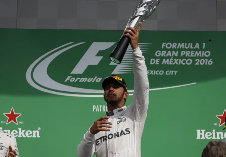 Lewis Hamilton muestra el trofeo de campeón. /Foto AP