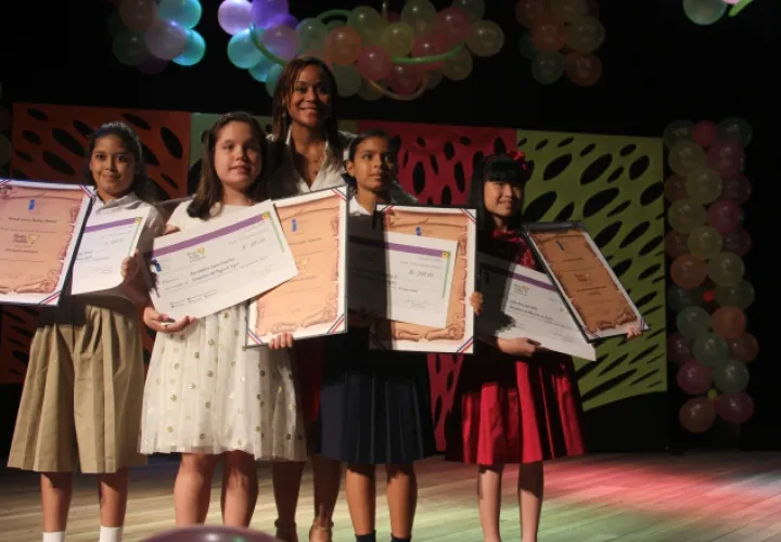 Las niñas galardonadas con el certamen literario reciben el diploma de parte de Janelle Davidson, directora del Inac. /Foto Cortesía