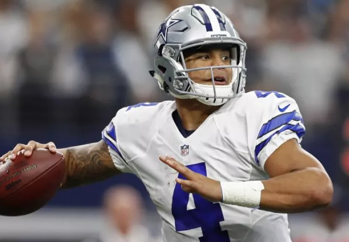 Dak Prescott  le pasa el ovoide a uno de sus compañeros. /Foto EFE