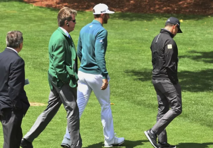 Dustin Johnson (centro) en su retirada del 'green'. /Foto AP