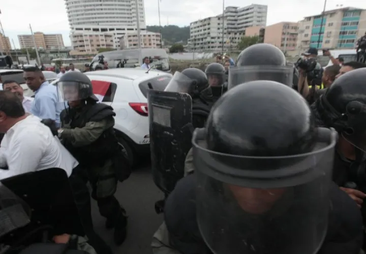 Forcejeo entre antimotines y transportistas. 