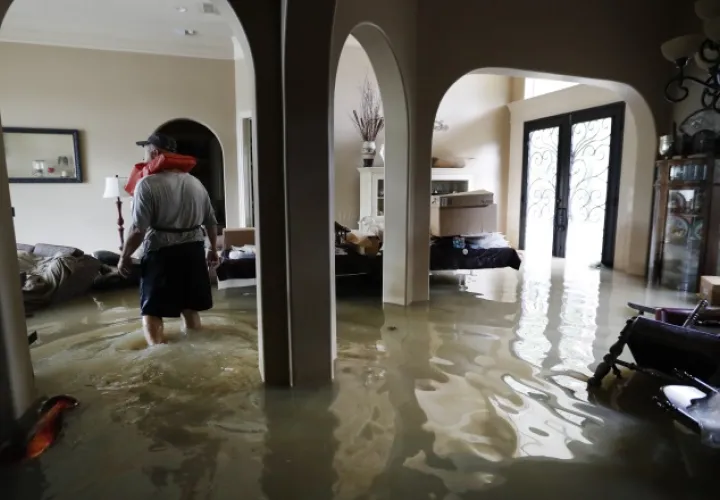 Mike Stamps, camina por su casa totalmente inundada. /Foto AP 