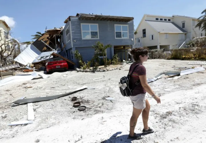 Una joven camina en medio de las casas destruidas por el huracán Irma. /Foto AP