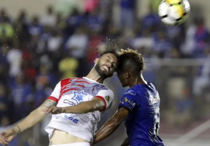 Algandona (d) del Árabe Unido disputa el balón con José Garro. /Foto EFE