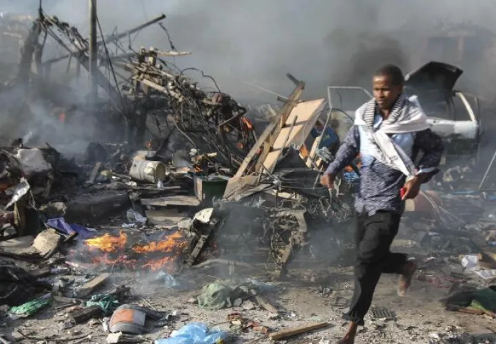 Un hombre atraviesa la escena de la explosión masiva frente a Safari Hotel. /Foto EFE