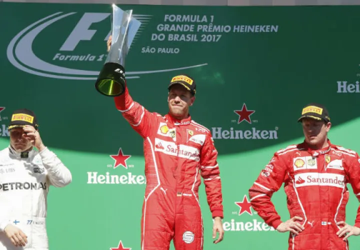 El piloto alemán Sebastian Vettel (Cent.), de la escudería Ferrari, celebra su victoria acompañado del piloto finlandés Valtteri Bottas (Izq), de la escudería Mercedes, que ha quedado en segundo puesto y el finlandés Kimi raikkonen de Ferrari (Deer.), que celebra el teercer lugar. Foto:EFE