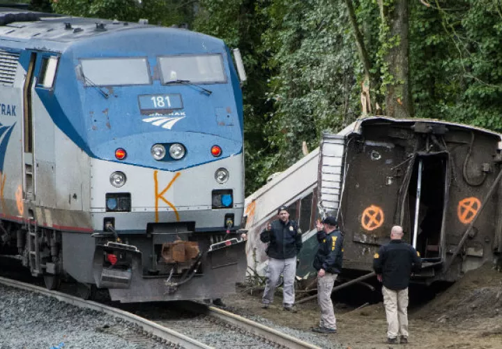 Las cuadrillas de emergencia realizan labores de rescate tras descarrilarse el tren.